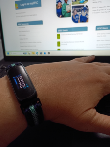 Fitbit tracker resting on a modern laptop keyboard